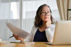 mature professional seated at a desk with paper and computer