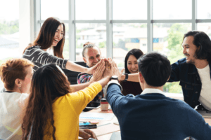 group of excited professionals high-fiving each other