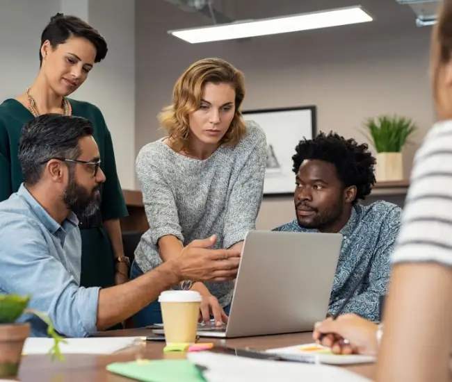 group of compliance professionals meeting around computer